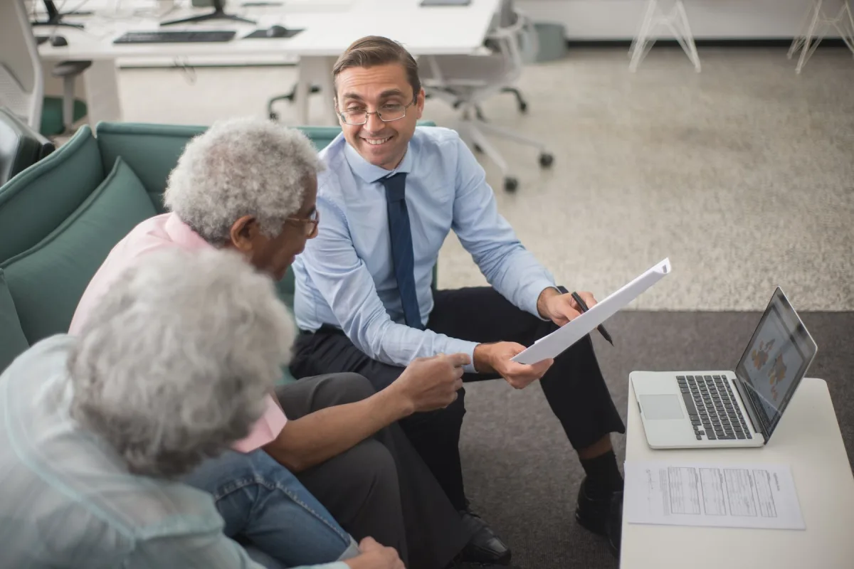 An adviser going through a financial plan with a couple in an office